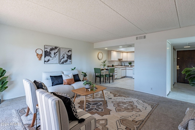 carpeted living room featuring a textured ceiling