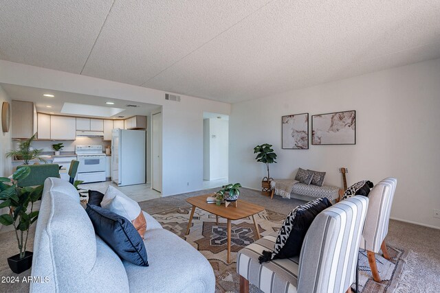 carpeted living room featuring a textured ceiling