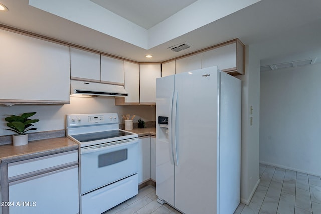 kitchen with light tile patterned floors, white appliances, and white cabinetry