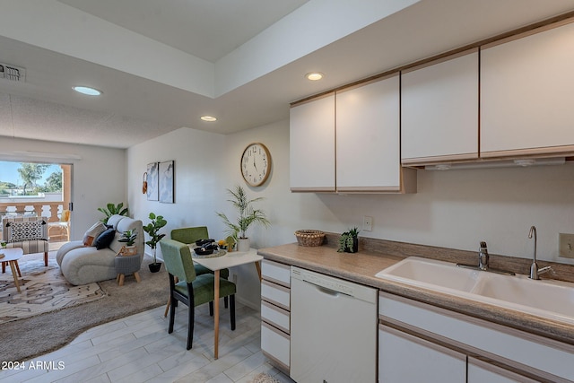 kitchen featuring white cabinets, sink, white dishwasher, and light hardwood / wood-style floors