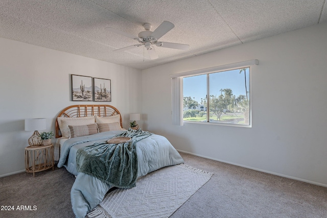 carpeted bedroom with ceiling fan and a textured ceiling