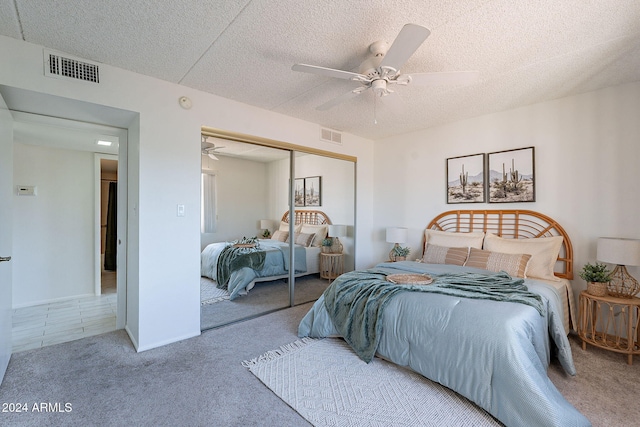 bedroom featuring ceiling fan, a closet, carpet, and a textured ceiling