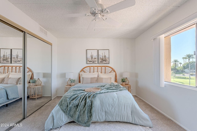 bedroom with light carpet, a textured ceiling, a closet, and ceiling fan