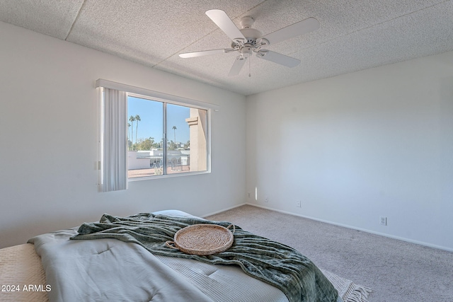 unfurnished bedroom featuring carpet, a textured ceiling, and ceiling fan