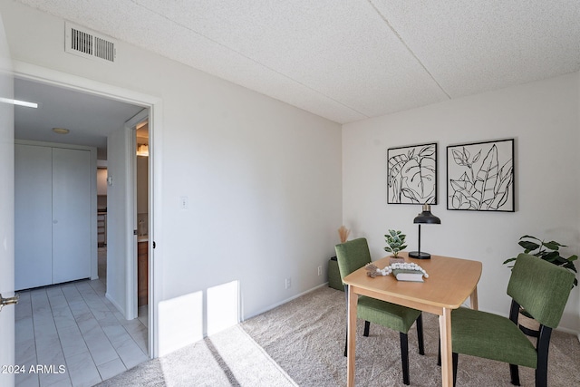 carpeted dining area featuring a textured ceiling