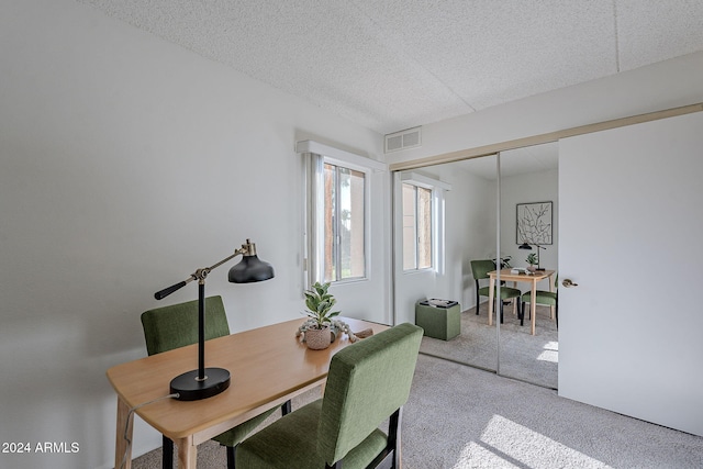 dining room with light carpet and a textured ceiling