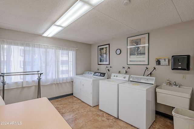 clothes washing area with independent washer and dryer and sink