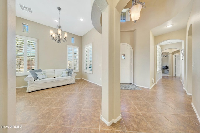 unfurnished living room featuring an inviting chandelier and light tile patterned floors