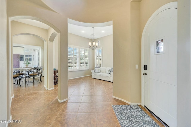 tiled entryway featuring an inviting chandelier