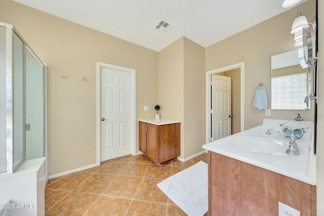 bathroom with tile patterned flooring, vanity, and walk in shower