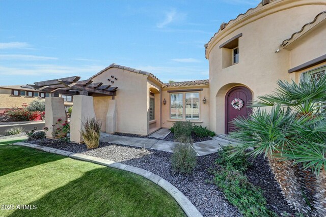 doorway to property featuring a yard and a pergola