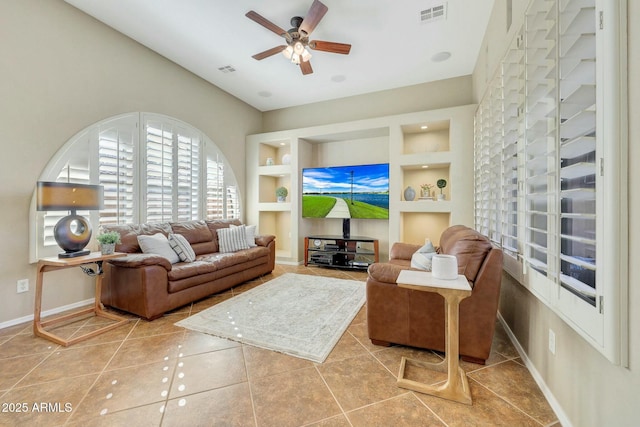 tiled living room with built in shelves and ceiling fan