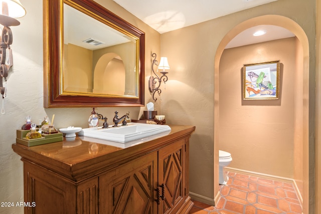 bathroom with tile patterned flooring, vanity, and toilet