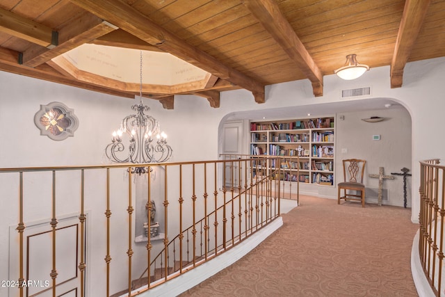 corridor with carpet flooring, beam ceiling, wooden ceiling, and a chandelier