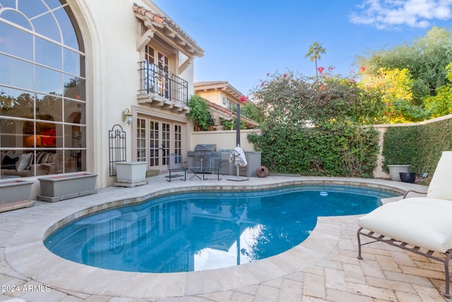 view of pool featuring a patio area, grilling area, and french doors