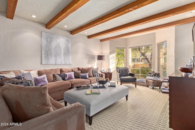 carpeted living room featuring beam ceiling and a textured ceiling