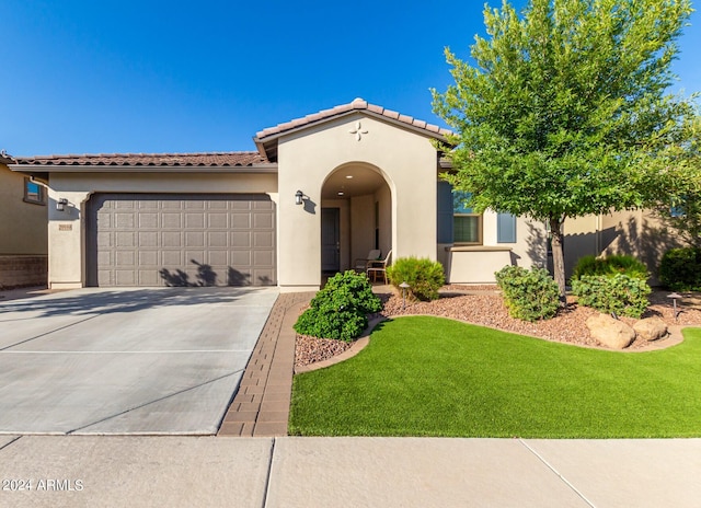 mediterranean / spanish-style home with a garage and a front yard