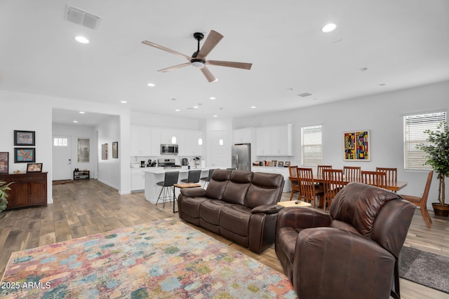 living room with recessed lighting, visible vents, light wood finished floors, and ceiling fan