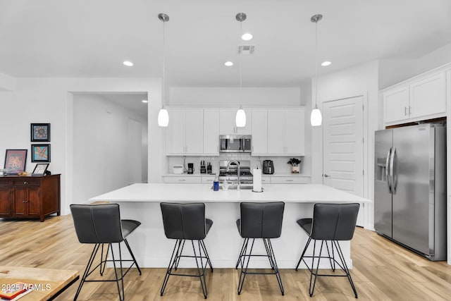 3913 W Mcneil St, Laveen, AZ 85339 - kitchen with visible vents, tasteful backsplash, appliances with stainless steel finishes, and light wood finished floors