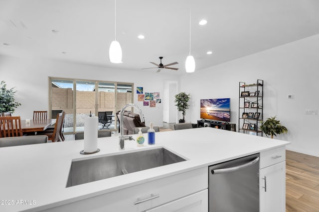 3913 W Mcneil St, Laveen, AZ 85339 - kitchen featuring a sink, stainless steel dishwasher, wood finished floors, white cabinetry, and hanging light fixtures