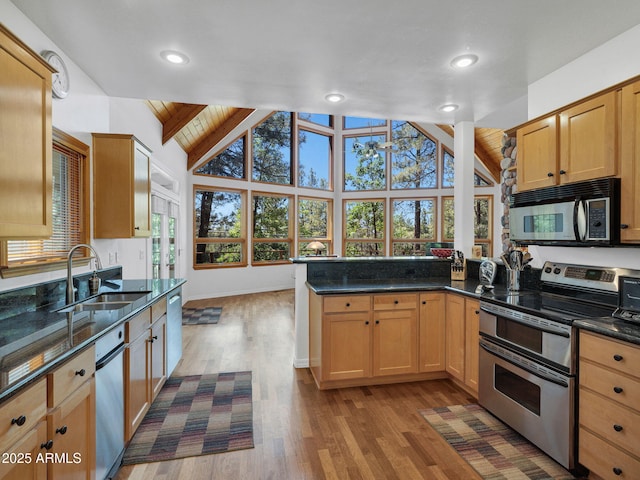525 E Turkey Trl, Munds Park, AZ 86017 - kitchen with stainless steel appliances, wood finished floors, a peninsula, dark stone countertops, and recessed lighting