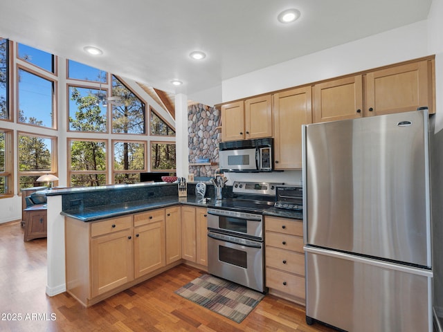 525 E Turkey Trl, Munds Park, AZ 86017 - kitchen with stainless steel appliances, light brown cabinets, a peninsula, and light wood-style floors