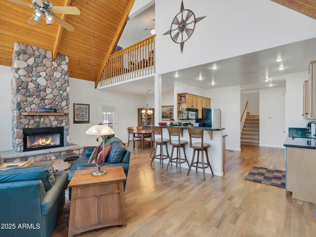 525 E Turkey Trl, Munds Park, AZ 86017 - living area with high vaulted ceiling, ceiling fan, light wood finished floors, a stone fireplace, and stairway