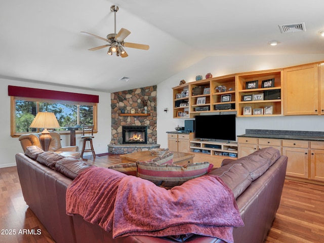 525 E Turkey Trl, Munds Park, AZ 86017 - living room with lofted ceiling, a ceiling fan, light wood-type flooring, and a stone fireplace