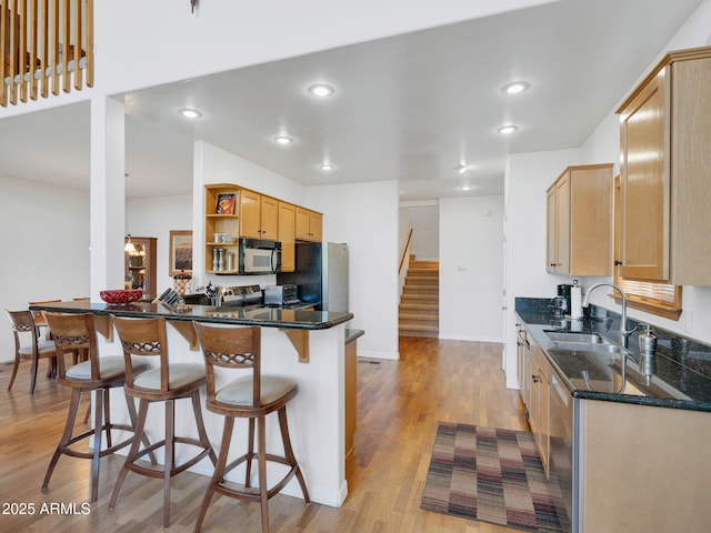 525 E Turkey Trl, Munds Park, AZ 86017 - kitchen featuring open shelves, light wood finished floors, a kitchen breakfast bar, dark stone counters, and freestanding refrigerator