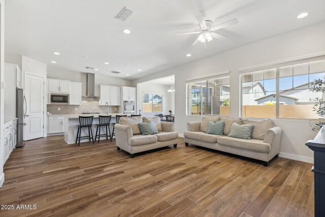 20606 E Avenida Del Valle Ct, Queen Creek, AZ 85142 - living area with visible vents, plenty of natural light, wood finished floors, and ceiling fan with notable chandelier