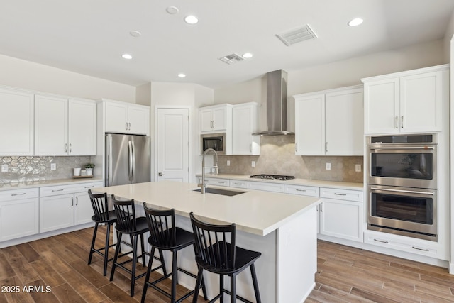 20606 E Avenida Del Valle Ct, Queen Creek, AZ 85142 - kitchen with wall chimney range hood, stainless steel appliances, visible vents, and a sink