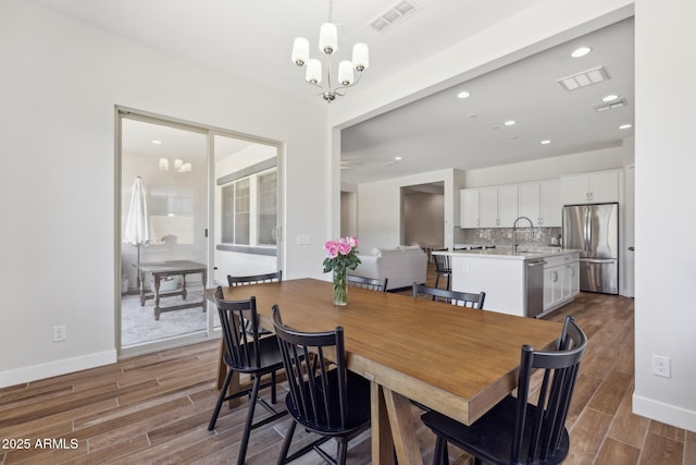 20606 E Avenida Del Valle Ct, Queen Creek, AZ 85142 - dining area with baseboards, a notable chandelier, wood finished floors, and visible vents
