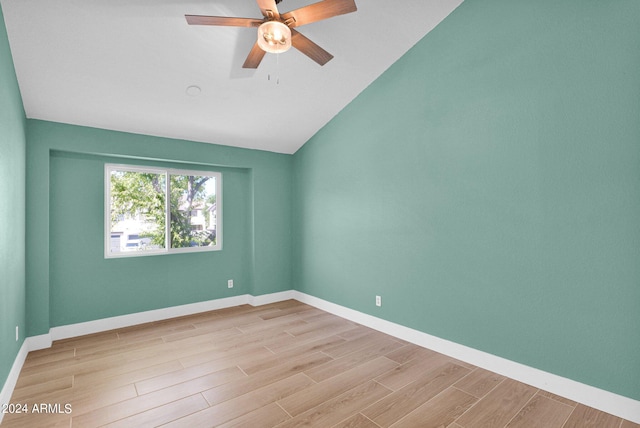 spare room featuring ceiling fan, light wood-type flooring, and vaulted ceiling