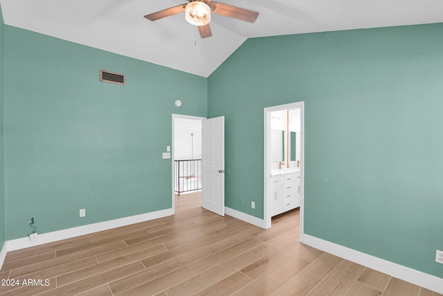 unfurnished bedroom with light wood-type flooring, vaulted ceiling, ceiling fan, and connected bathroom