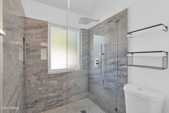 bathroom featuring walk in shower and toilet