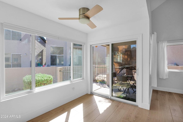 unfurnished sunroom with ceiling fan