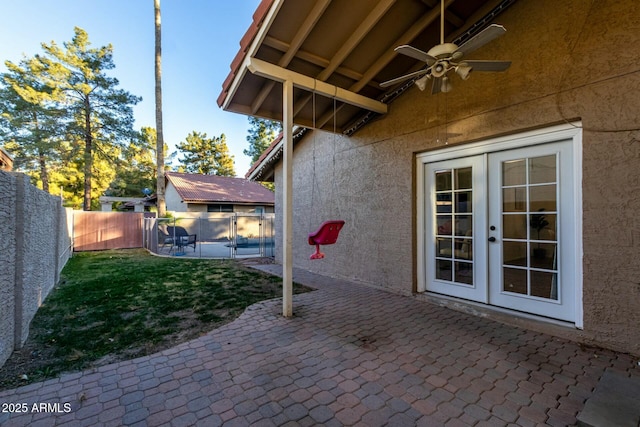 view of patio featuring ceiling fan, a pool, and french doors