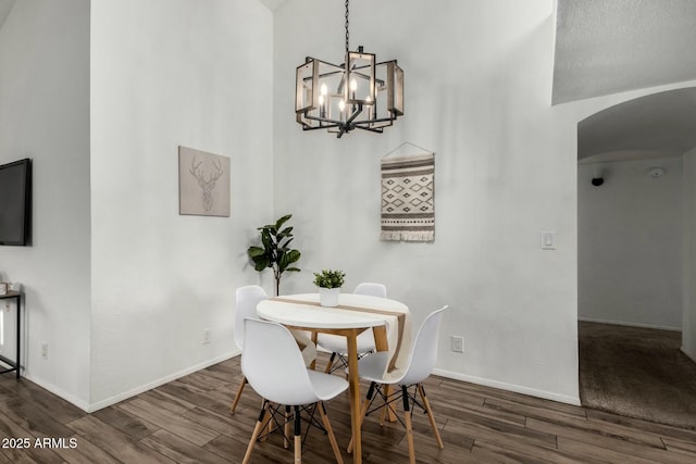 dining area with dark hardwood / wood-style flooring and a chandelier