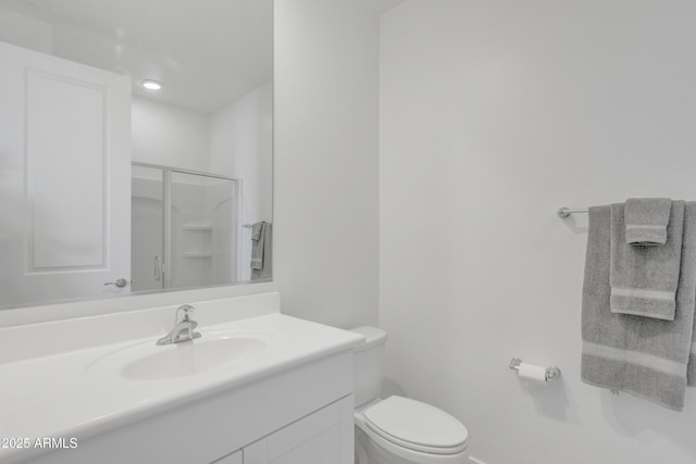 bathroom featuring a shower stall, toilet, and vanity