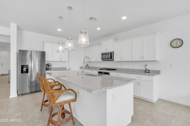 kitchen with stainless steel appliances, an island with sink, visible vents, and white cabinets