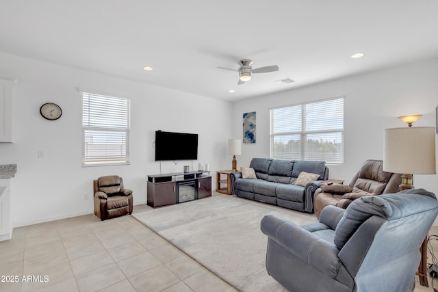 living room with light tile patterned floors, visible vents, baseboards, ceiling fan, and recessed lighting