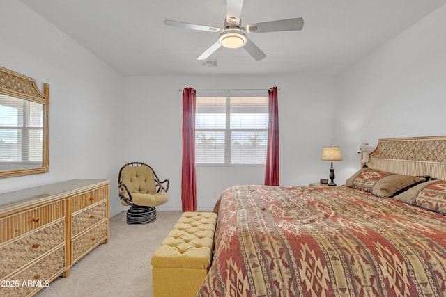 bedroom featuring ceiling fan, visible vents, and light colored carpet