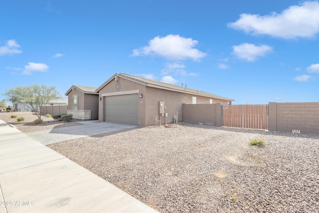 view of home's exterior featuring driveway, an attached garage, fence, and stucco siding