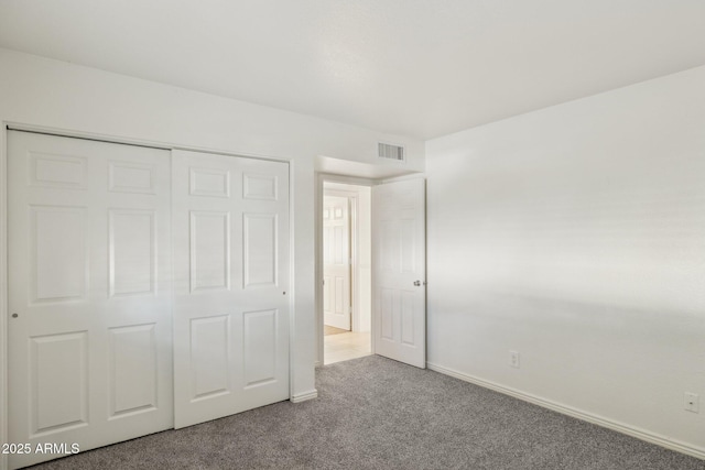 unfurnished bedroom featuring carpet flooring and a closet