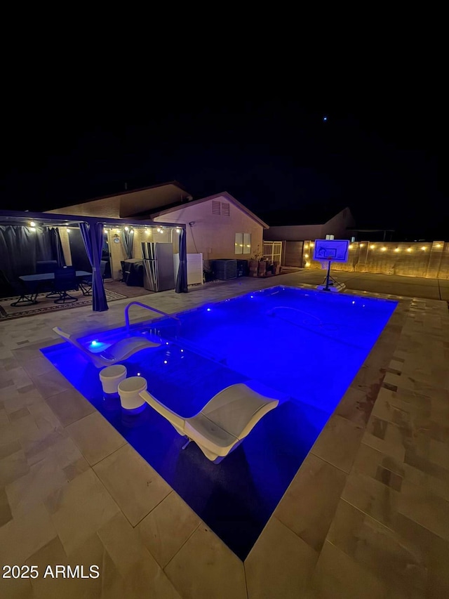 pool at twilight featuring a patio