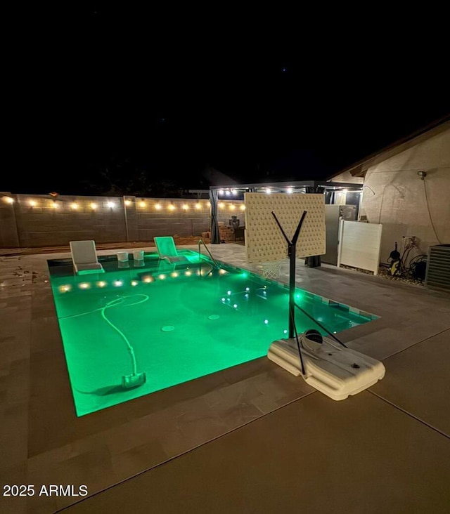 view of swimming pool featuring a patio, central AC unit, and fence