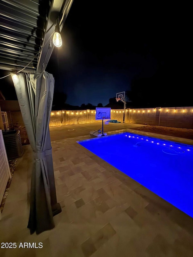 pool at night with central AC, fence, and basketball court