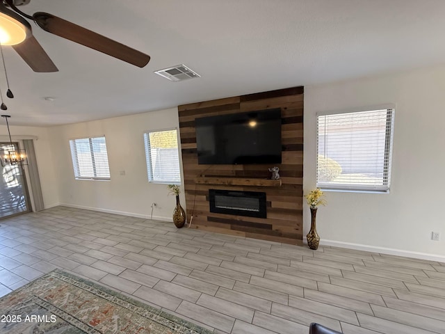 living room featuring a large fireplace, ceiling fan, visible vents, and baseboards