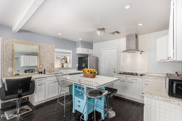 2802 E Virginia Ave, Phoenix, AZ 85008 - kitchen featuring wall chimney range hood, freestanding refrigerator, gas cooktop, dark wood-type flooring, and tasteful backsplash