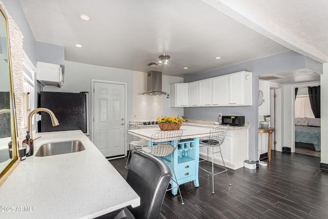 2802 E Virginia Ave, Phoenix, AZ 85008 - kitchen with wall chimney range hood, freestanding refrigerator, white cabinets, dark wood-style flooring, and black microwave